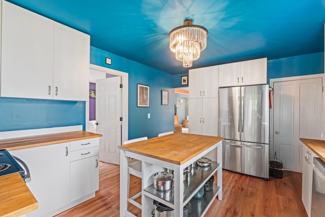 194 Larkin St, Bangor, ME 04401 - kitchen featuring stainless steel appliances, white cabinetry, a chandelier, and light wood finished floors