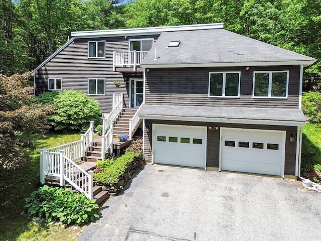 363 Winthrop Center Rd, Winthrop, ME 04364 - view of front of house with stairs, a balcony, driveway, an attached garage, and a shingled roof