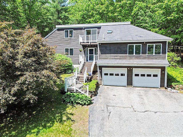 363 Winthrop Center Rd, Winthrop, ME 04364 - view of front of property with a balcony, driveway, a garage, stairway, and a view of trees