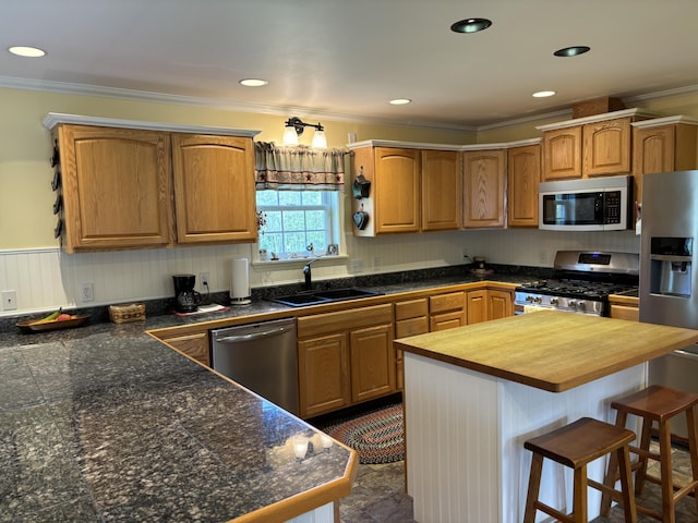 25 Raccoon Rd, Cushing, ME 04563 - kitchen with stainless steel appliances, butcher block countertops, crown molding, a kitchen bar, and a kitchen island