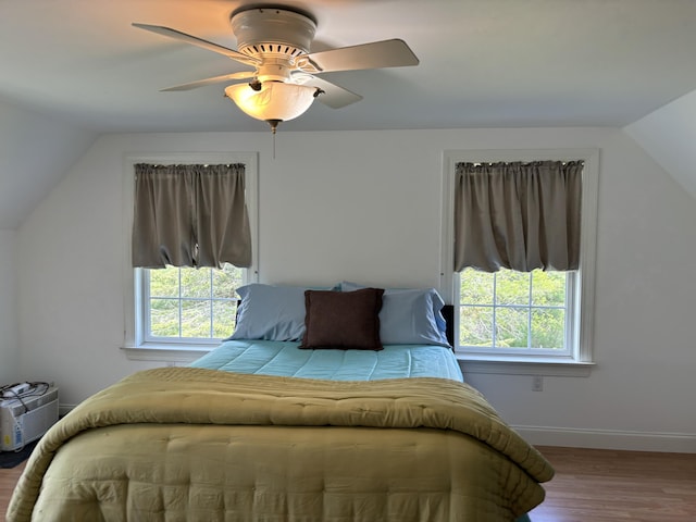 25 Raccoon Rd, Cushing, ME 04563 - bedroom with multiple windows, wood finished floors, lofted ceiling, and ceiling fan