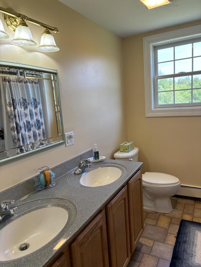 25 Raccoon Rd, Cushing, ME 04563 - bathroom featuring a baseboard heating unit, double vanity, a shower with curtain, and stone finish flooring
