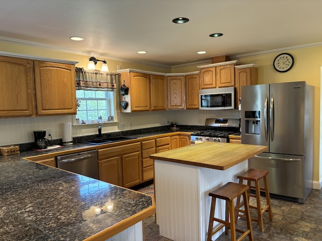 25 Raccoon Rd, Cushing, ME 04563 - kitchen featuring appliances with stainless steel finishes, butcher block countertops, ornamental molding, a breakfast bar area, and a center island