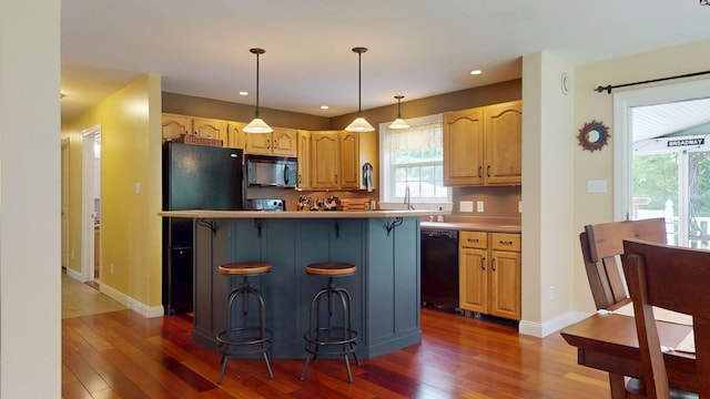 176 Weeks Rd, Gorham, ME 04038 - kitchen featuring black appliances, dark wood finished floors, a kitchen bar, plenty of natural light, and recessed lighting