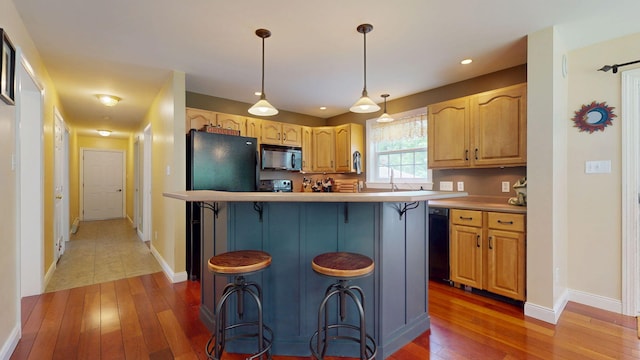 176 Weeks Rd, Gorham, ME 04038 - kitchen featuring black appliances, light wood-style flooring, a kitchen breakfast bar, baseboards, and recessed lighting