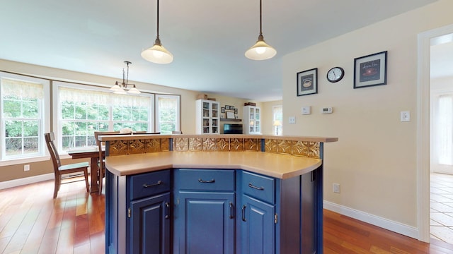 176 Weeks Rd, Gorham, ME 04038 - kitchen with blue cabinetry, light wood finished floors, baseboards, and light countertops