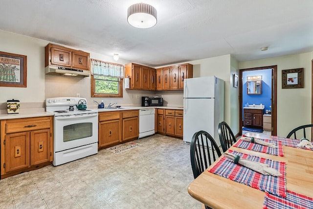 125 Lone Indian Trl, Augusta, ME 04330 - kitchen featuring white appliances, under cabinet range hood, brown cabinetry, light countertops, and a sink