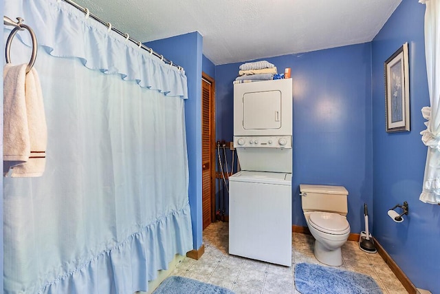 125 Lone Indian Trl, Augusta, ME 04330 - full bath featuring stacked washer / dryer, toilet, baseboards, tile patterned floors, and curtained shower