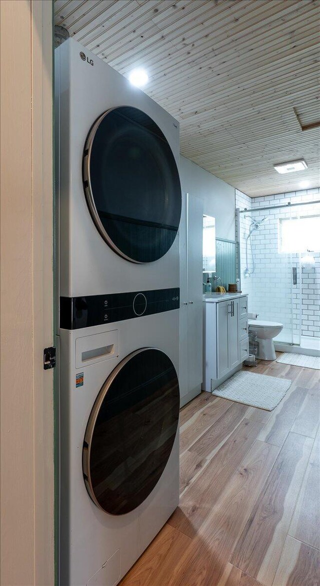 144 Woody Ln, Cushing, ME 04563 - laundry area with estacked washer and dryer, light wood-type flooring, and wood ceiling