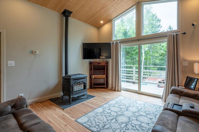 144 Woody Ln, Cushing, ME 04563 - living room with a wood stove, high vaulted ceiling, wood finished floors, wood ceiling, and baseboards