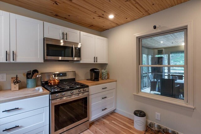 144 Woody Ln, Cushing, ME 04563 - kitchen with stainless steel appliances, wooden ceiling, light wood finished floors, light countertops, and white cabinets