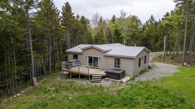 144 Woody Ln, Cushing, ME 04563 - rear view of property featuring a wooden deck, a wooded view, and metal roof