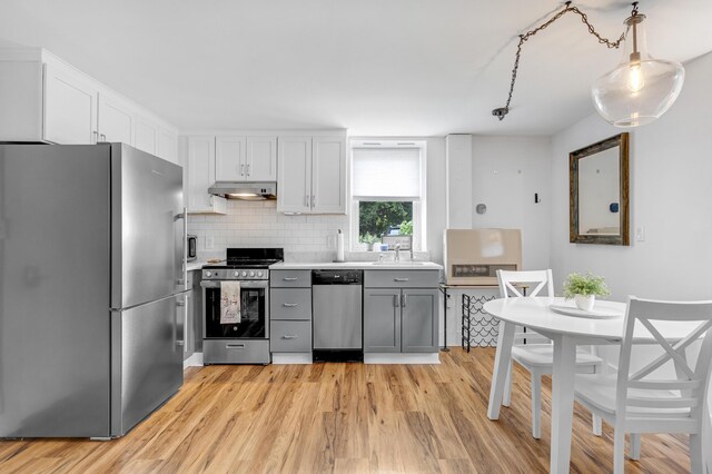15 Mill Hl Unit 2B, Bethel, ME 04217 - kitchen with appliances with stainless steel finishes, under cabinet range hood, a sink, light countertops, and light wood-style floors