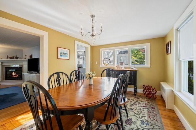 75 Ledgelawn Ave, Bar Harbor, ME 04609 - dining area with a chandelier, light wood-style floors, plenty of natural light, and a premium fireplace