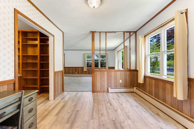165 Temple Ave Unit 1, Old Orchard Beach, ME 04064 - unfurnished living room with a baseboard heating unit, light wood-style flooring, a wainscoted wall, a textured ceiling, and wallpapered walls
