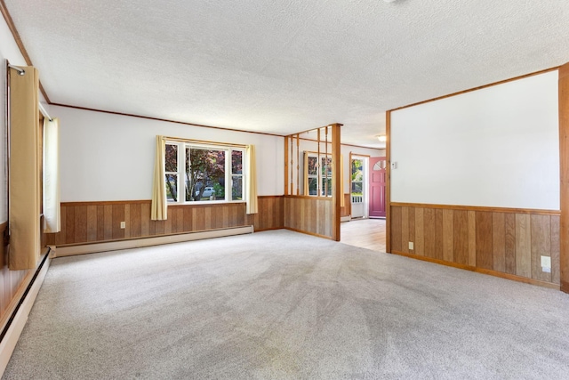165 Temple Ave Unit 1, Old Orchard Beach, ME 04064 - carpeted empty room with wainscoting, baseboard heating, wooden walls, a textured ceiling, and ornamental molding