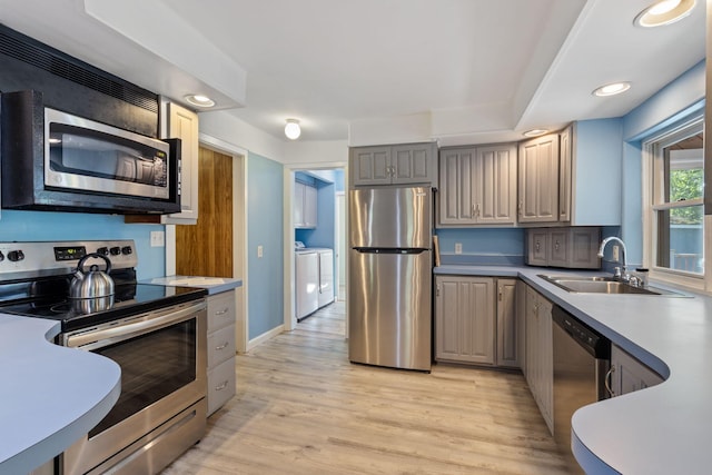 165 Temple Ave Unit 1, Old Orchard Beach, ME 04064 - kitchen featuring stainless steel appliances, a sink, washer and clothes dryer, light wood-type flooring, and gray cabinets