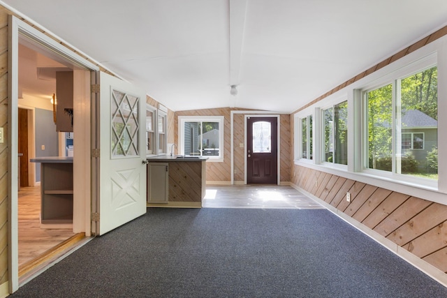 165 Temple Ave Unit 1, Old Orchard Beach, ME 04064 - unfurnished sunroom featuring wooden walls, lofted ceiling, carpet floors, and baseboards