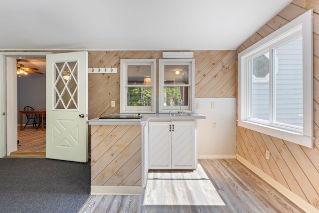 165 Temple Ave Unit 1, Old Orchard Beach, ME 04064 - kitchen featuring baseboards, wooden walls, light countertops, light wood-style floors, and a sink