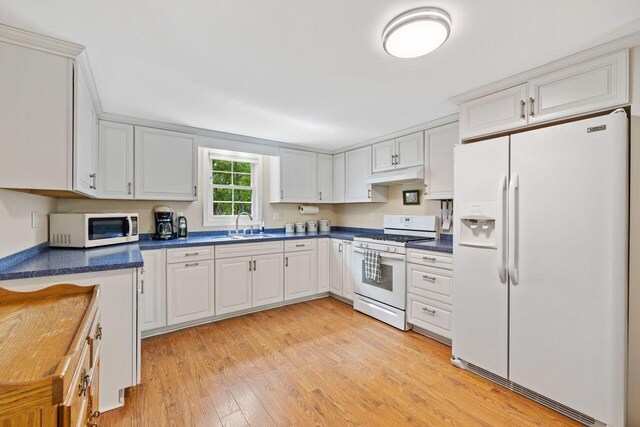 16 Van Buren Dr, Newfield, ME 04095 - kitchen featuring white appliances, under cabinet range hood, dark countertops, and light wood finished floors