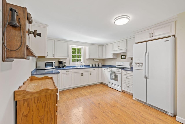 16 Van Buren Dr, Newfield, ME 04095 - kitchen featuring white appliances, a sink, dark countertops, light wood finished floors, and under cabinet range hood