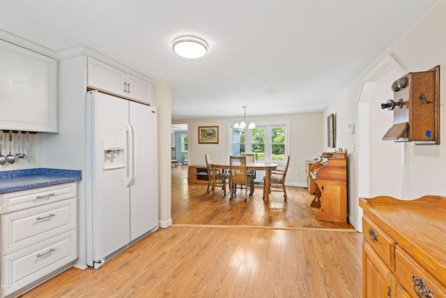 16 Van Buren Dr, Newfield, ME 04095 - kitchen featuring white fridge with ice dispenser, light wood-style flooring, white cabinetry, a chandelier, and decorative light fixtures