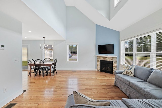 12 Haleys Ct Unit 21, Wells, ME 04090 - living area featuring high vaulted ceiling, a chandelier, light wood finished floors, baseboards, and a fireplace