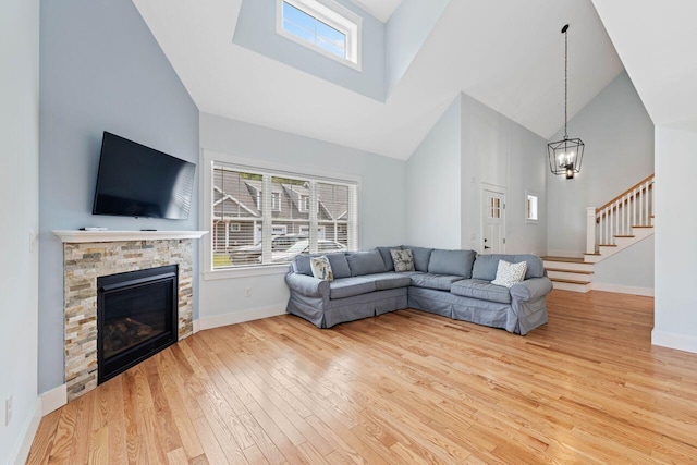 12 Haleys Ct Unit 21, Wells, ME 04090 - living room featuring high vaulted ceiling, wood finished floors, baseboards, stairway, and a chandelier