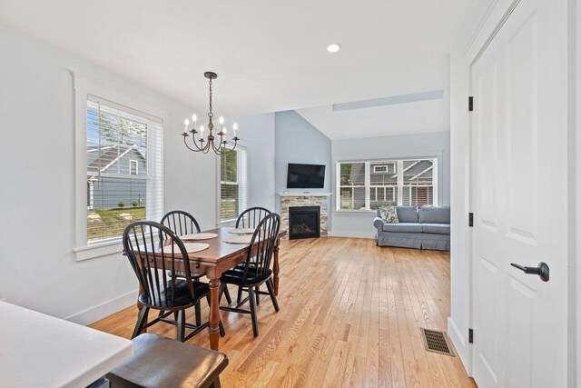 12 Haleys Ct Unit 21, Wells, ME 04090 - dining area with baseboards, a chandelier, light wood finished floors, a fireplace, and vaulted ceiling