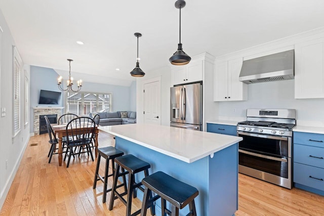 12 Haleys Ct Unit 21, Wells, ME 04090 - kitchen with appliances with stainless steel finishes, wall chimney range hood, open floor plan, light wood-style flooring, and recessed lighting