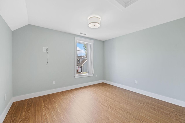 12 Haleys Ct Unit 21, Wells, ME 04090 - empty room with wood finished floors, baseboards, and vaulted ceiling