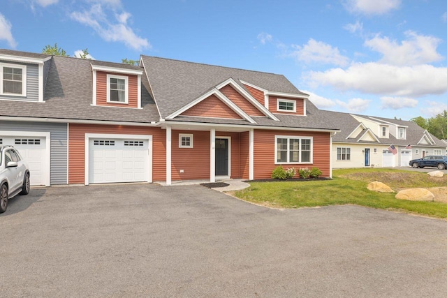 12 Haleys Ct Unit 21, Wells, ME 04090 - view of front of home with asphalt driveway, a front yard, roof with shingles, and a garage