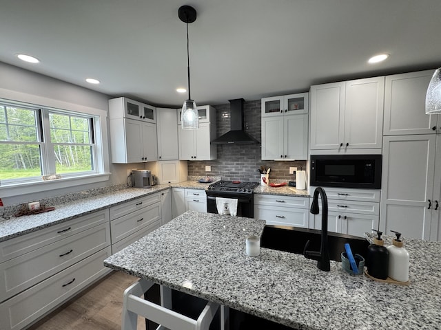 588 Mason Bay Rd, Jonesport, ME 04649 - kitchen with wall chimney range hood, black appliances, glass insert cabinets, wood finished floors, and recessed lighting