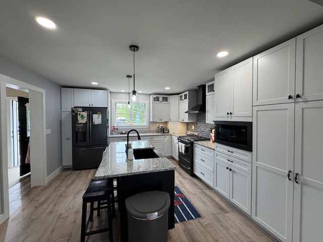 588 Mason Bay Rd, Jonesport, ME 04649 - kitchen with black appliances, a sink, white cabinets, decorative backsplash, and light wood finished floors