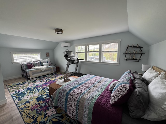 588 Mason Bay Rd, Jonesport, ME 04649 - bedroom with lofted ceiling, multiple windows, a wall unit AC, wood finished floors, and baseboards