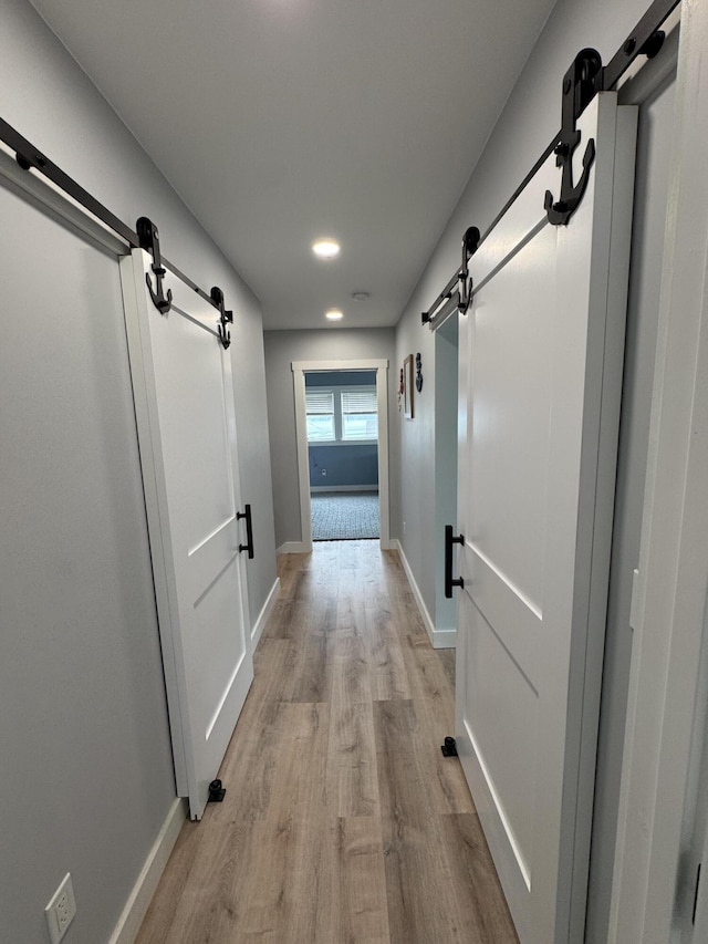 588 Mason Bay Rd, Jonesport, ME 04649 - hall featuring a barn door, light wood-style flooring, recessed lighting, and baseboards