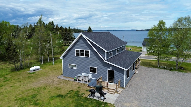 588 Mason Bay Rd, Jonesport, ME 04649 - back of house featuring roof with shingles, a deck with water view, and a lawn