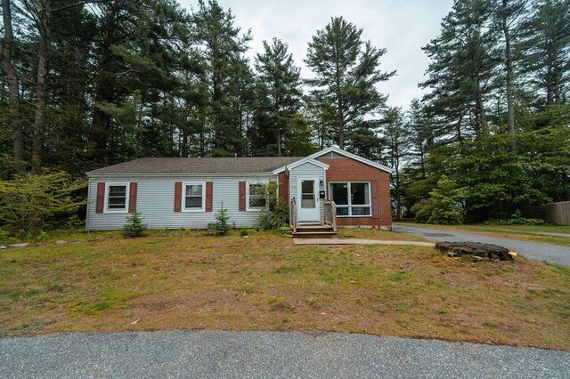 56 Intrepid St, Brunswick, ME 04011 - view of front facade featuring entry steps, a front lawn, and view of scattered trees