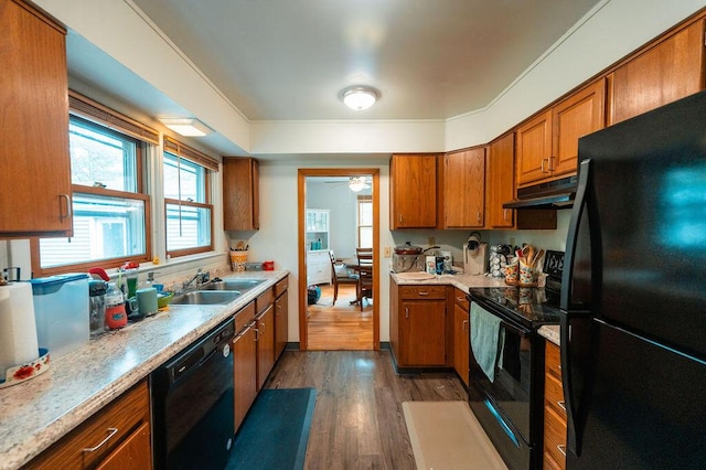 56 Intrepid St, Brunswick, ME 04011 - kitchen featuring black appliances, a sink, under cabinet range hood, brown cabinets, and dark wood-type flooring
