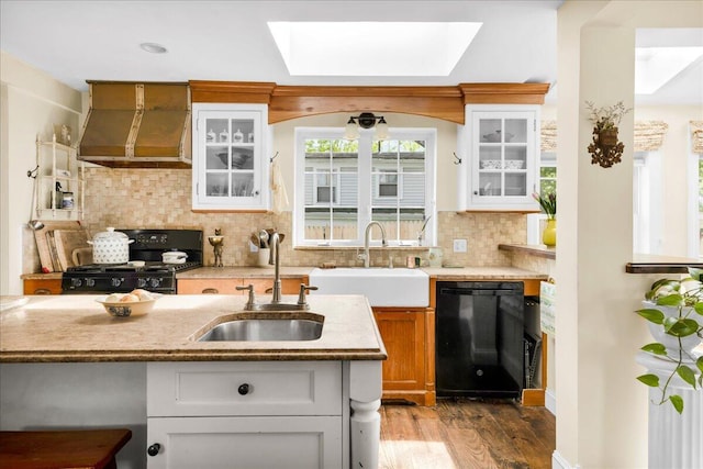 44 Bridge St, Bucksport, ME 04416 - kitchen with black appliances, ventilation hood, a skylight, and a sink