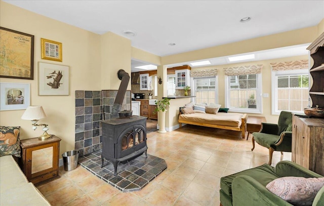 44 Bridge St, Bucksport, ME 04416 - living room with a wood stove, light tile patterned floors, and baseboards