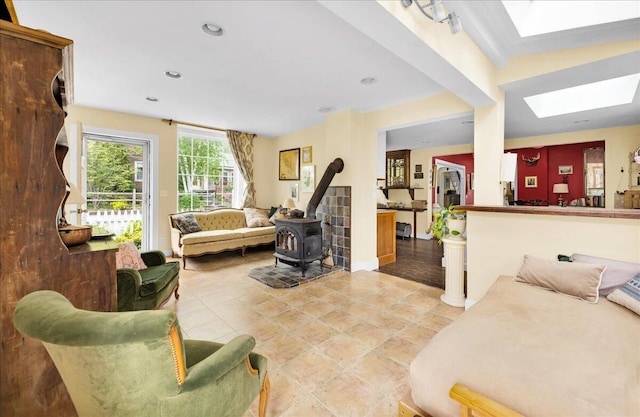 44 Bridge St, Bucksport, ME 04416 - living room featuring a skylight, a wood stove, light tile patterned floors, baseboards, and recessed lighting
