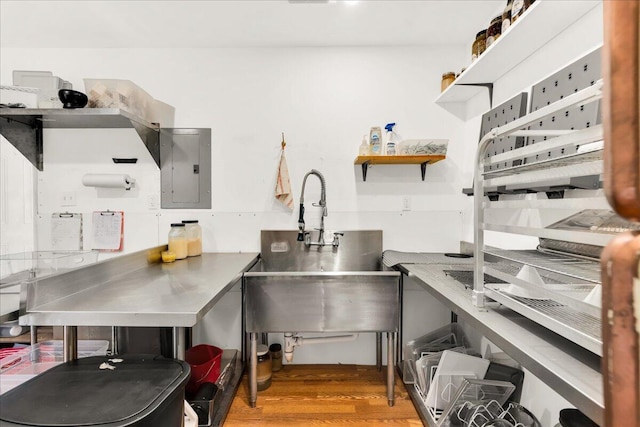 44 Bridge St, Bucksport, ME 04416 - kitchen with stainless steel countertops, electric panel, open shelves, wood finished floors, and a sink