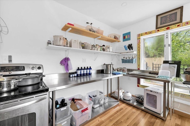 44 Bridge St, Bucksport, ME 04416 - kitchen featuring stainless steel countertops, stainless steel electric stove, light wood-style flooring, open shelves, and white microwave