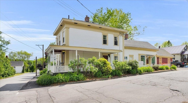 44 Bridge St, Bucksport, ME 04416 - view of front facade featuring covered porch, a chimney, and asphalt driveway