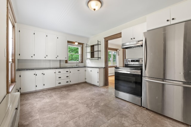 127 Lake St, Auburn, ME 04210 - kitchen with appliances with stainless steel finishes, under cabinet range hood, white cabinetry, dark countertops, and a sink