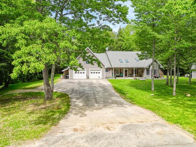 42 Lee Dr, Albion, ME 04910 - view of front of house with a porch, driveway, a garage, a front yard, and a shingled roof