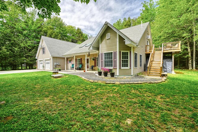 42 Lee Dr, Albion, ME 04910 - view of front of property with stairway, concrete driveway, a front yard, a wooden deck, and roof with shingles