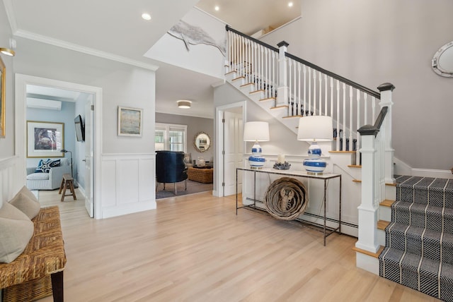 18 Forest Hill Ln, Kennebunk, ME 04043 - foyer entrance with light wood-type flooring, stairs, crown molding, a wainscoted wall, and a decorative wall