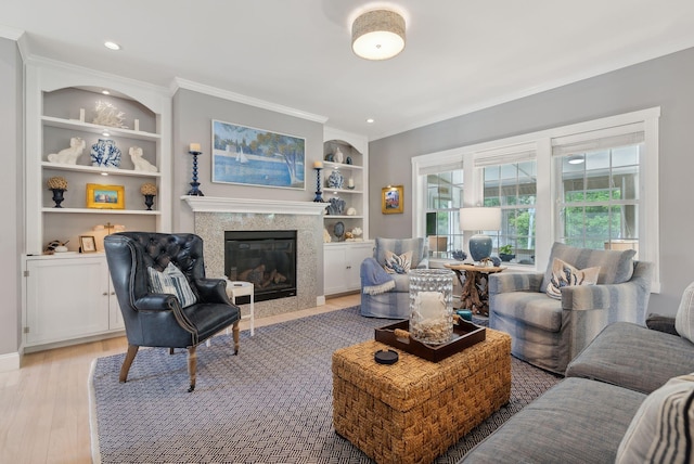 18 Forest Hill Ln, Kennebunk, ME 04043 - living room featuring light wood-type flooring, a fireplace, built in shelves, crown molding, and recessed lighting